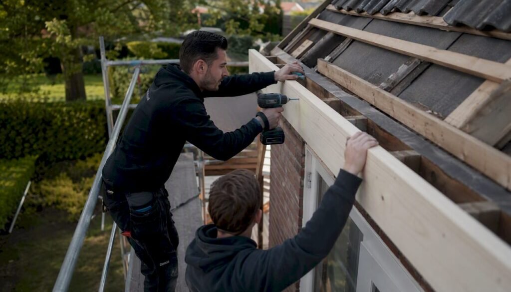 Dakdekkers zijn bezig met het vervangen van de boeiboorden aan het huis.