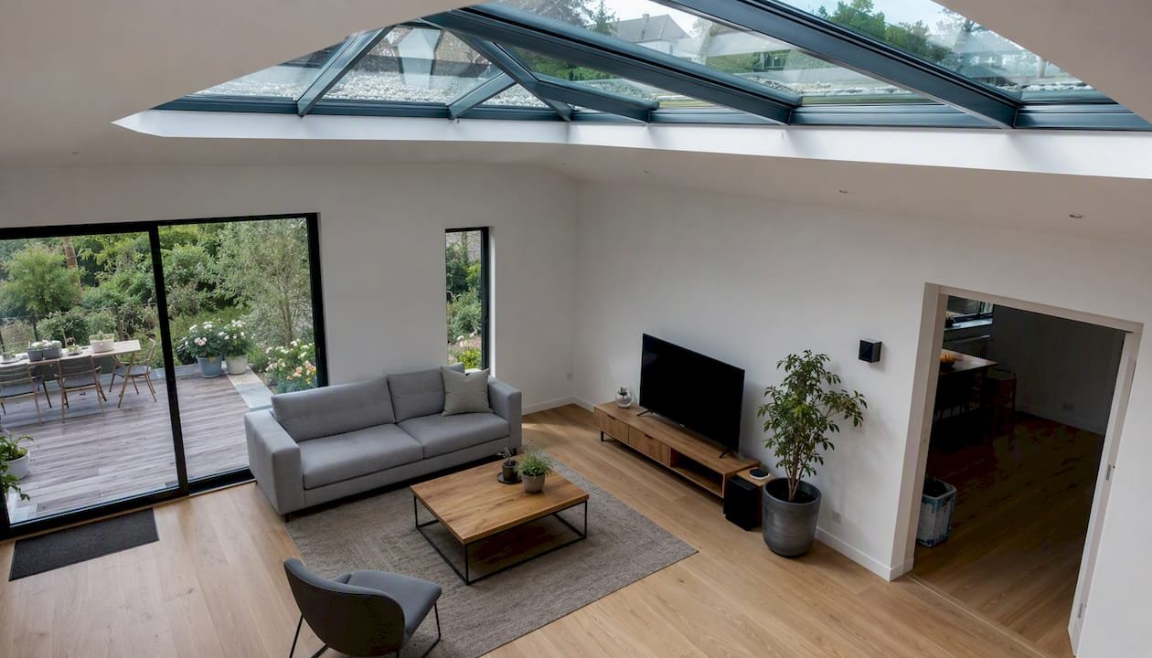 De woonkamer baadt in het natuurlijke licht dat via de lichtstraat naar binnen stroomt.