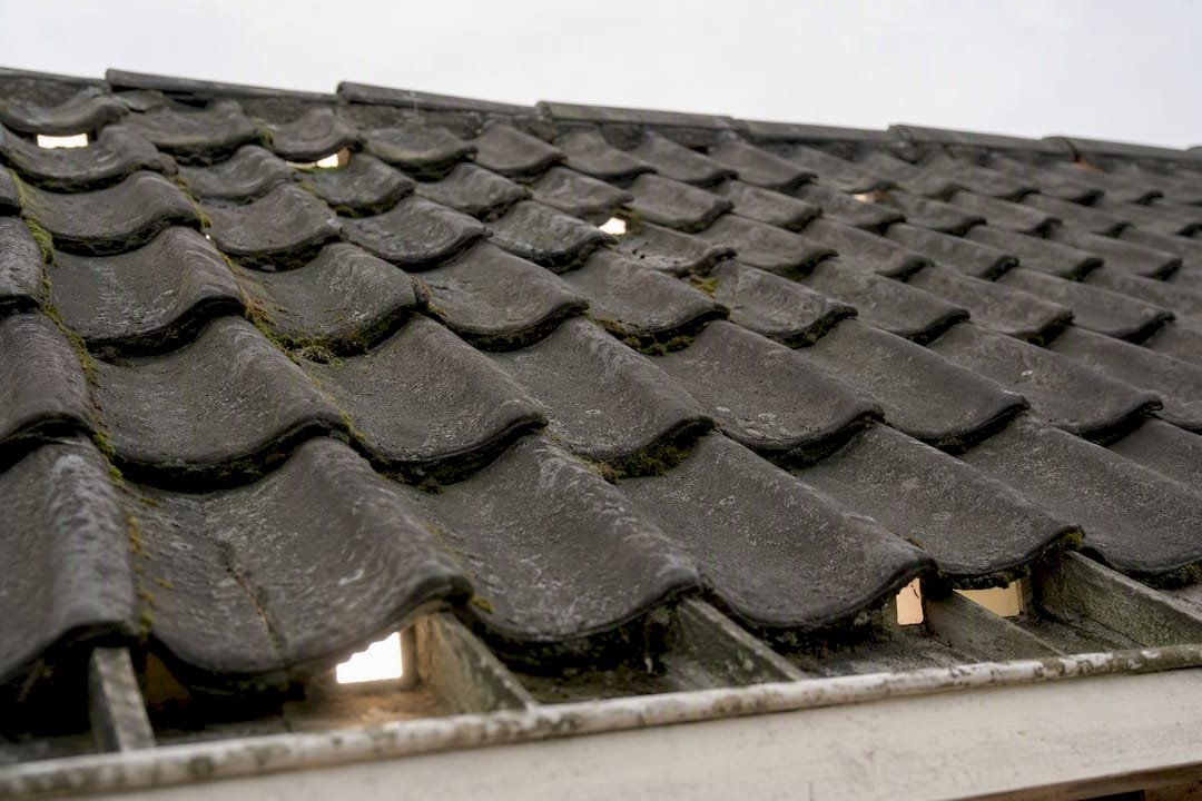 Detailopname van ventilatieopeningen onder dakpannen