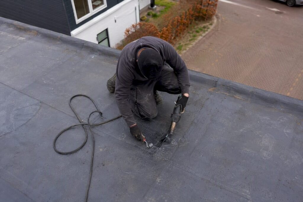 Dakdekker repareert blaren op bitumen dak