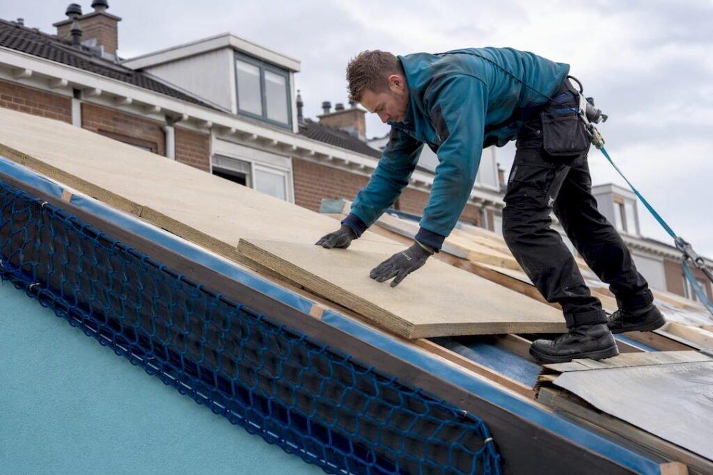 Dakdekker brengt isolatie aan tijdens dakrenovatie