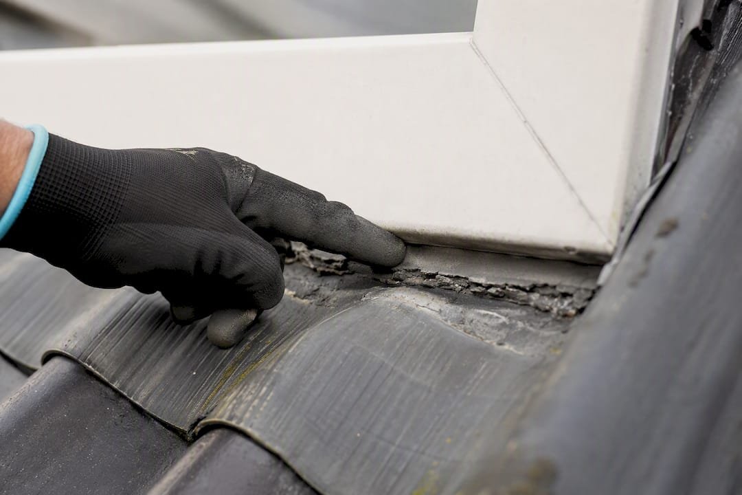 Dakdekker inspecteert versleten kitnaad