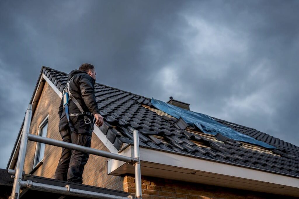 Dakdekker beoordeelt de schade aan dakpannen na storm