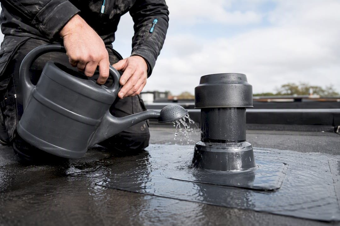 Dakdekker controleert afdichting met gietwatertest