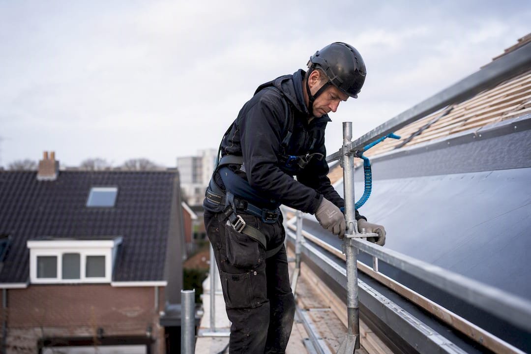 Dakdekker controleert de tijdelijke valbeveiliging