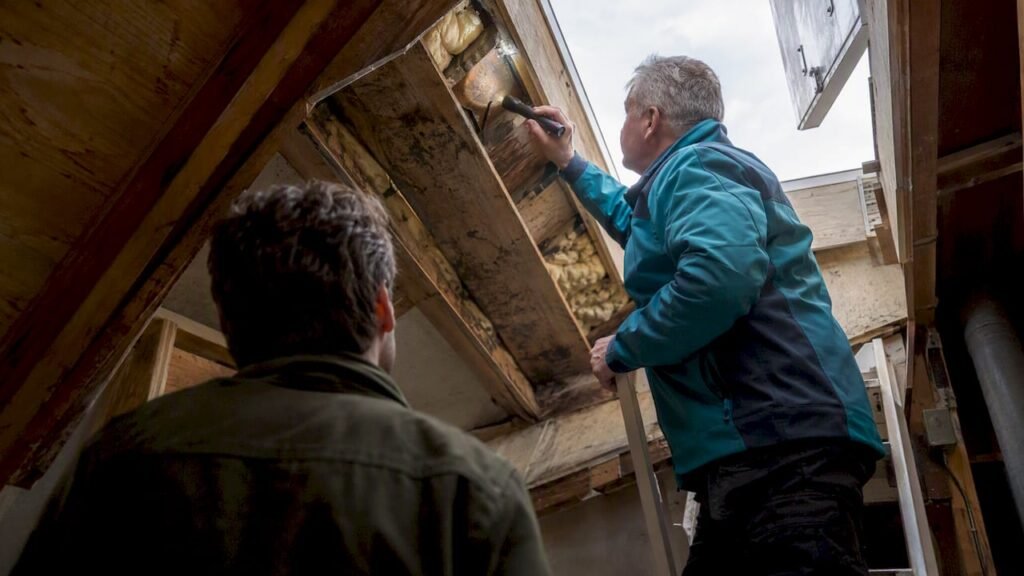 Dakinspecteur inspecteert het dak van het aangekochte huis