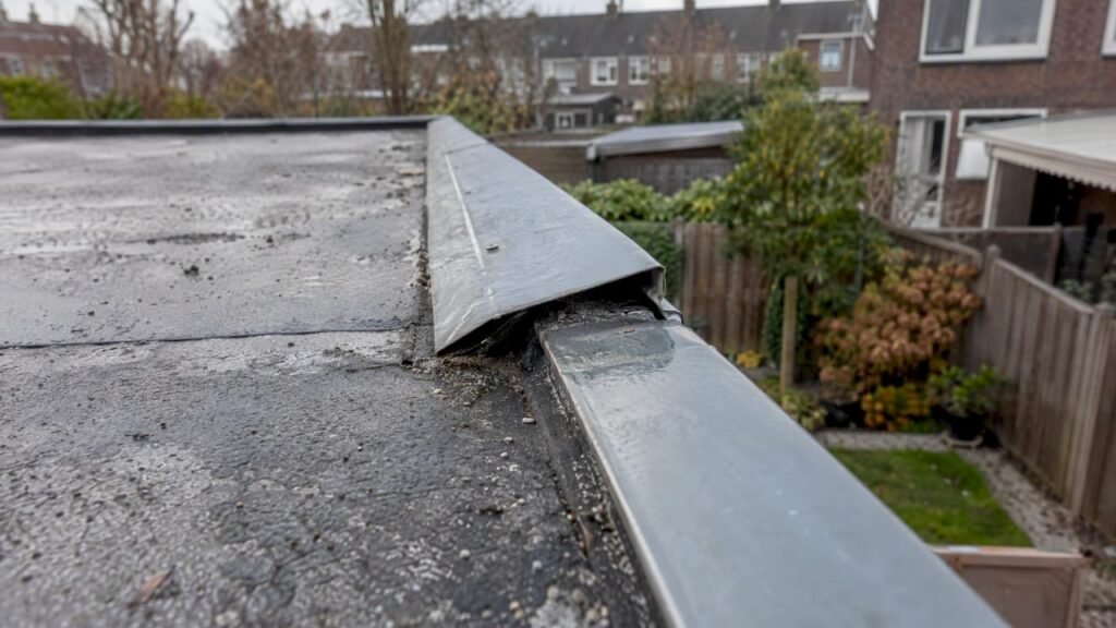 Loszittende metalen dakrand op plat dak