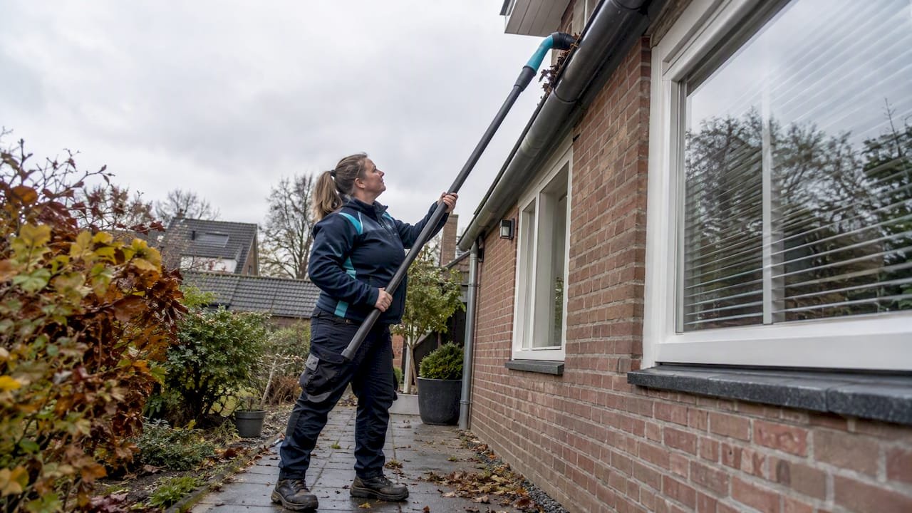 Dakdekker maakt dakgoot schoon vanaf de grond