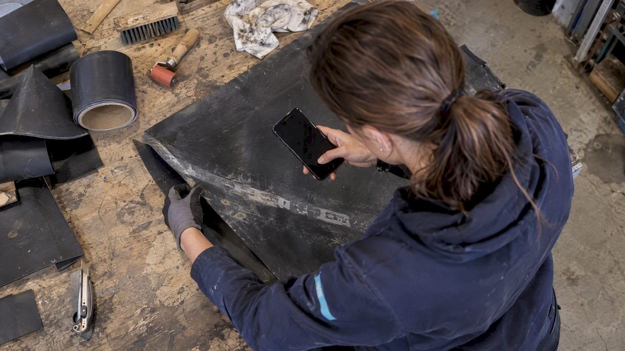 Dakdekker maakt foto van opdruk op EPDM-dakbedekking